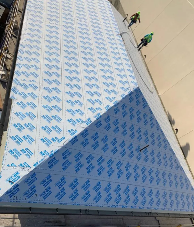 Professional roofers installing underlayment on a metal roof in Pontiac